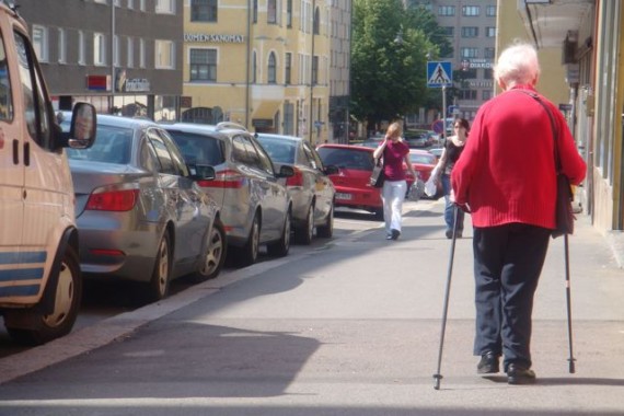 Elderly woman walking using cross country ski poles