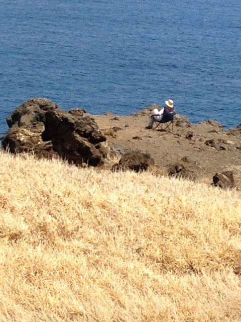 Person sitting at Hawaiian ocean front cliff view