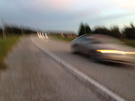 Blurry car passing runner along highway