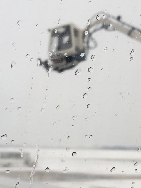 Looking out a Delta jet window at de-icing truck