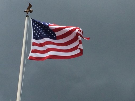 American Flag blowing in the wind against a dark sky