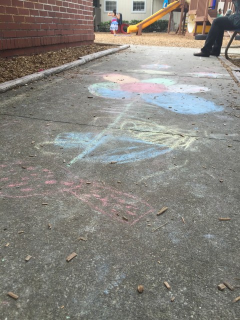 Toddler chalk art on sidewalk