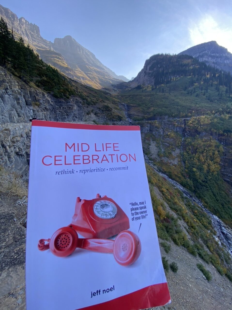 Book entitled mid life celebration with mountains in the background
