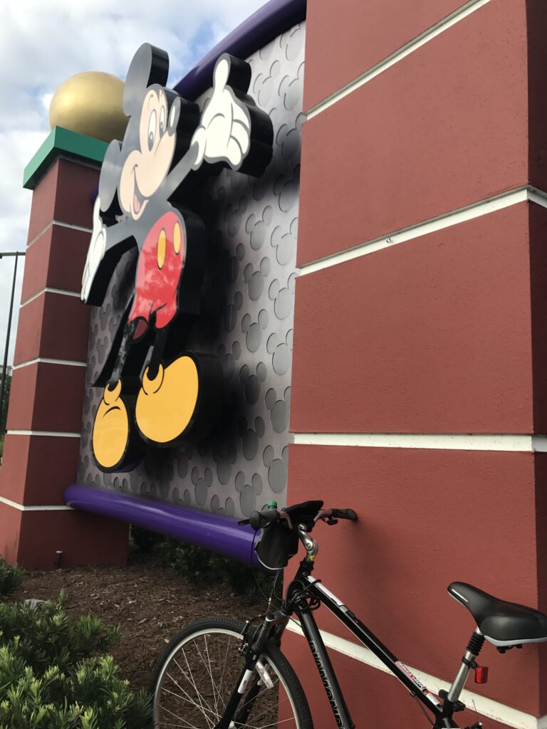 Bicycle park next to large Mickey Mouse welcome sign