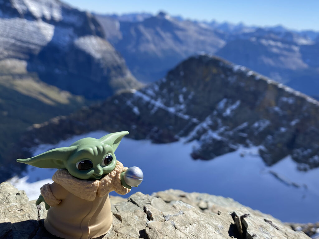 Baby Yoda toy on mountain summit