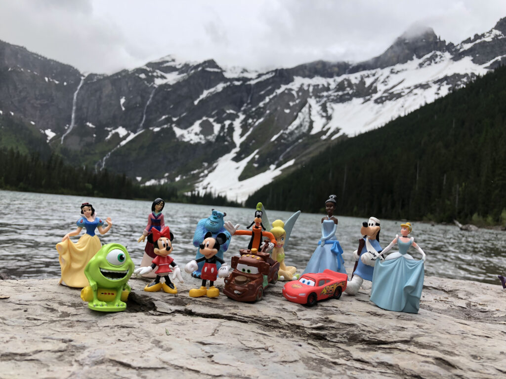 Disney plastic character toys at a mountain lake