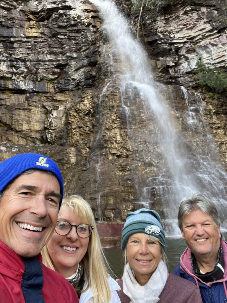 Four people at a waterfall