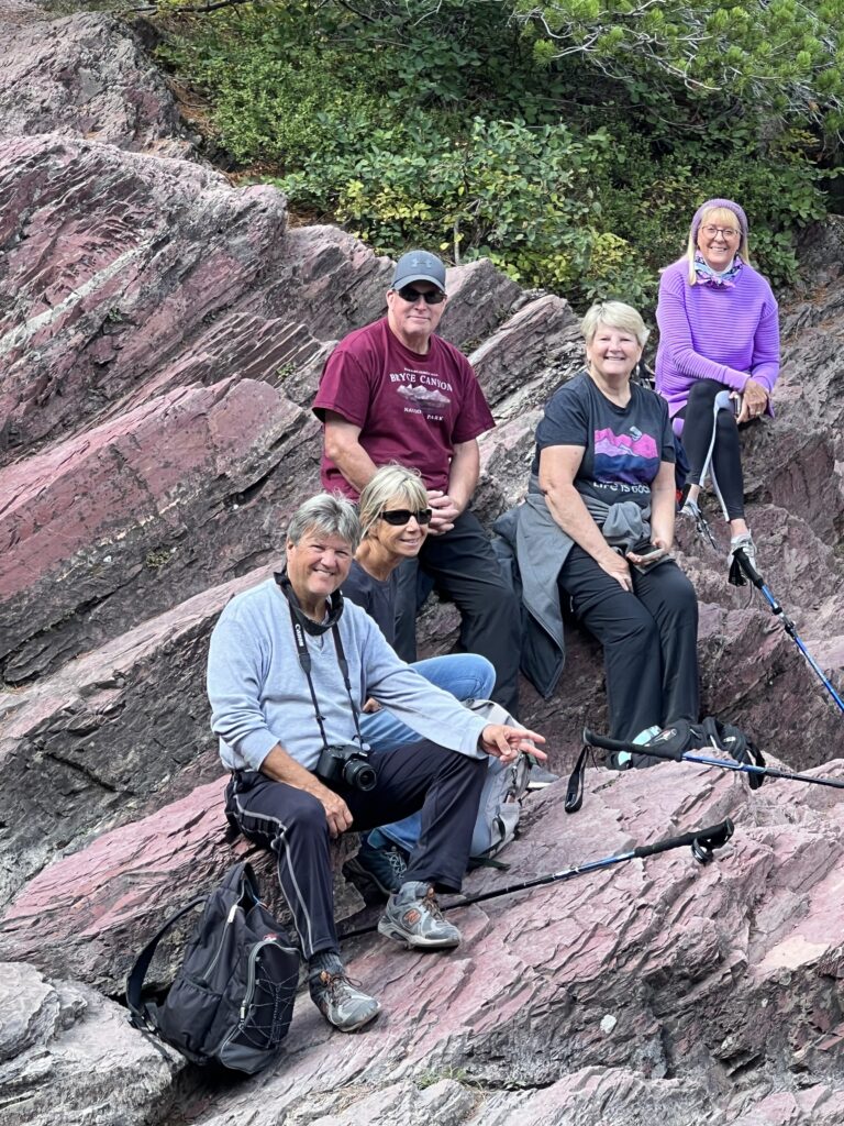 Five hikers sitting on some rocks
