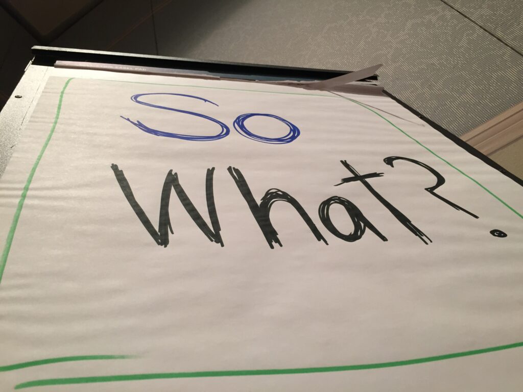 flip chart with the words 'so what' written on it