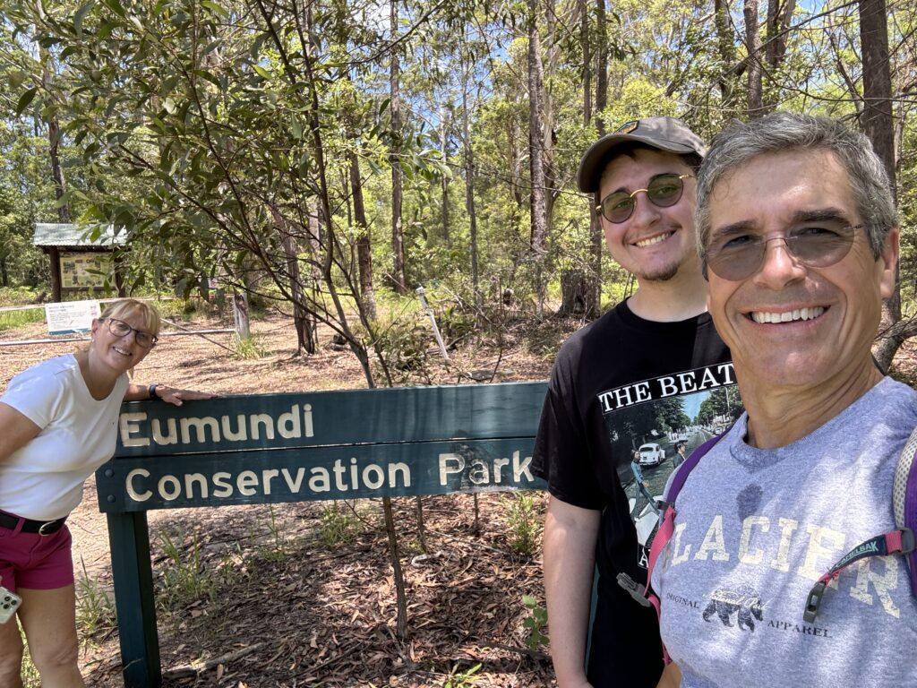 Three adults at National park sign