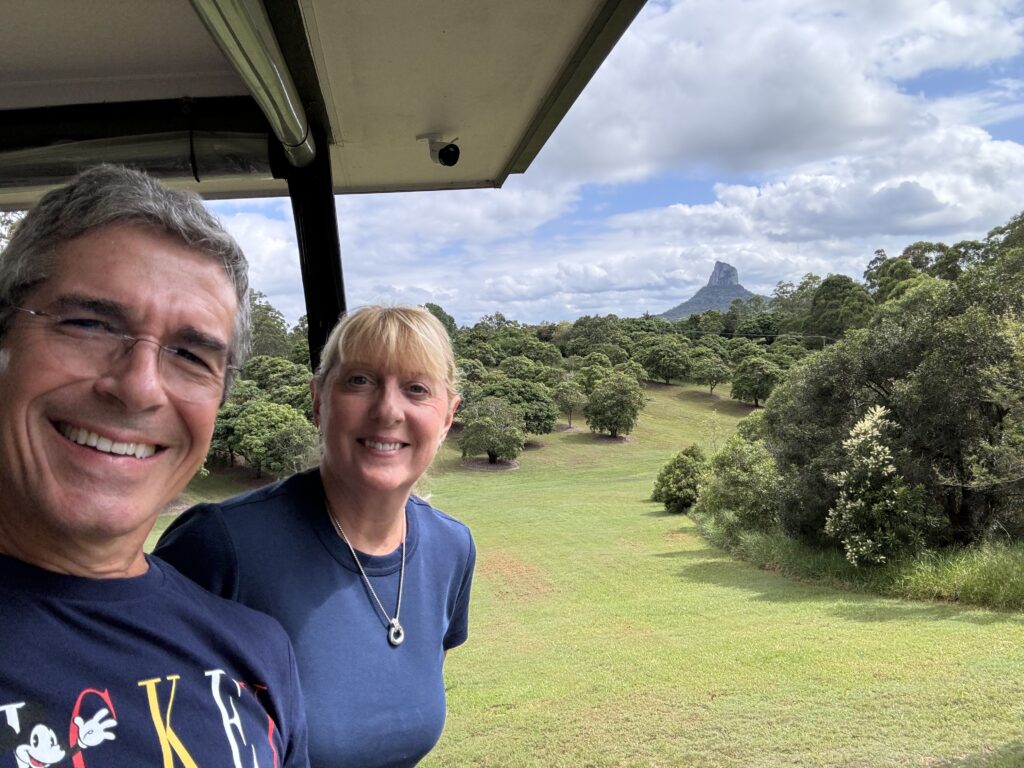 Two people posing with a mountain in the background