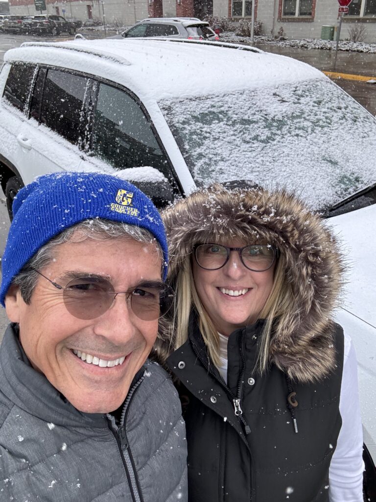 Couple next to snow covered car