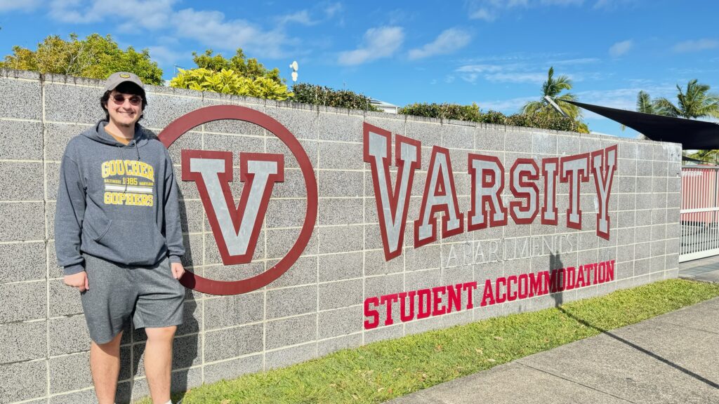 student by apartment sign