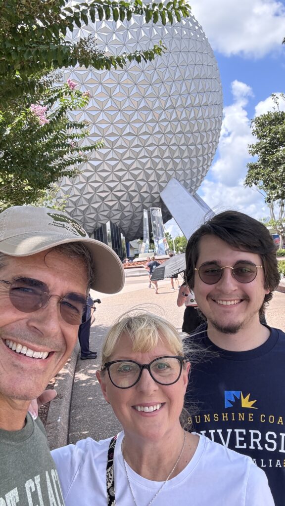 Family of three in front of spaceship earth at Epcot