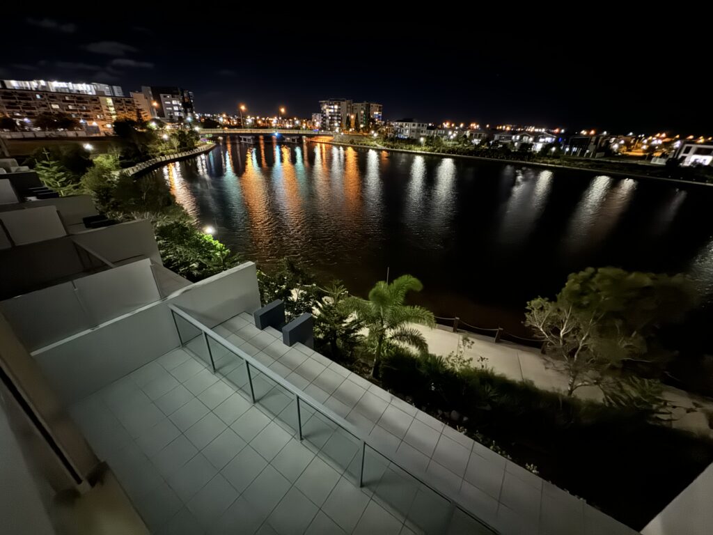 Waterfront view from a hotel room balcony at night