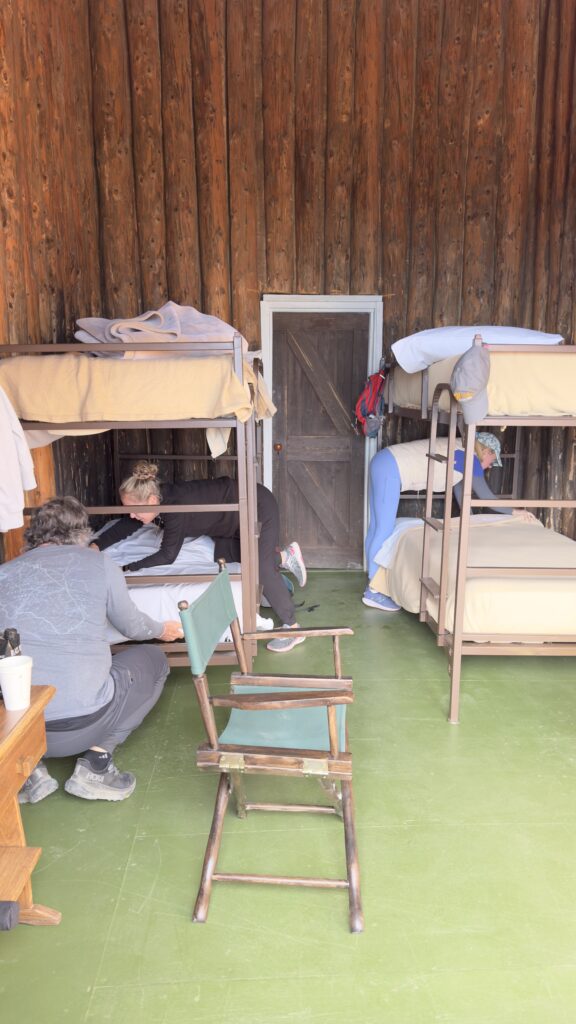 Three people making their beds in a mountain chalet