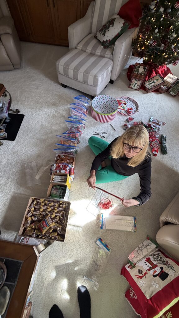 Woman sitting on the floor with bags of Christmas goodies