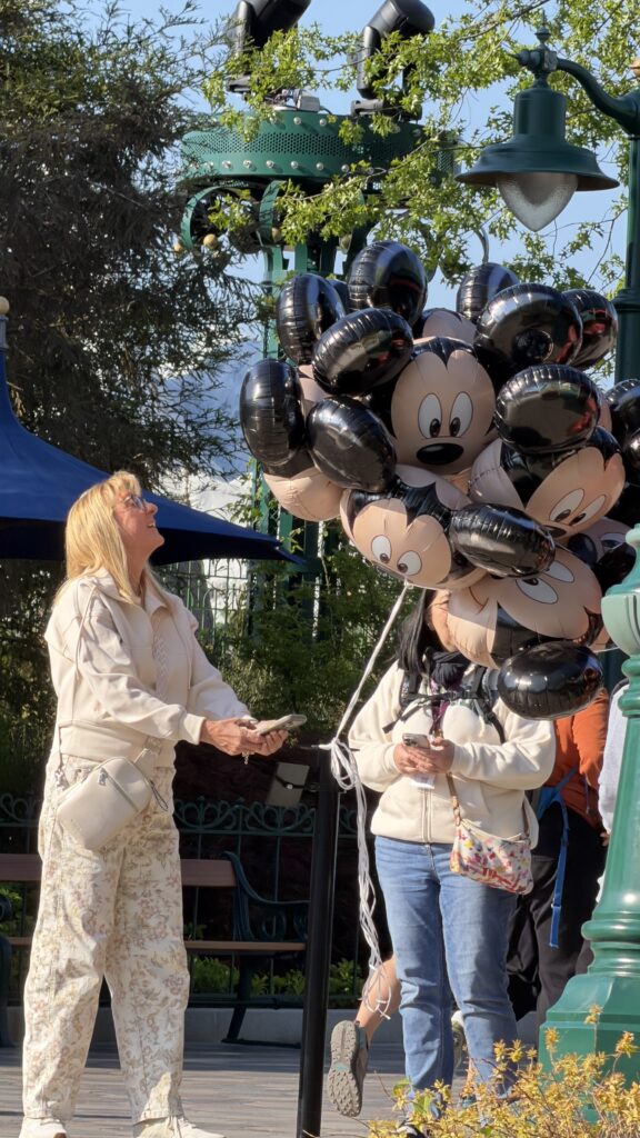 Woman next to a bunch of big Disney balloons