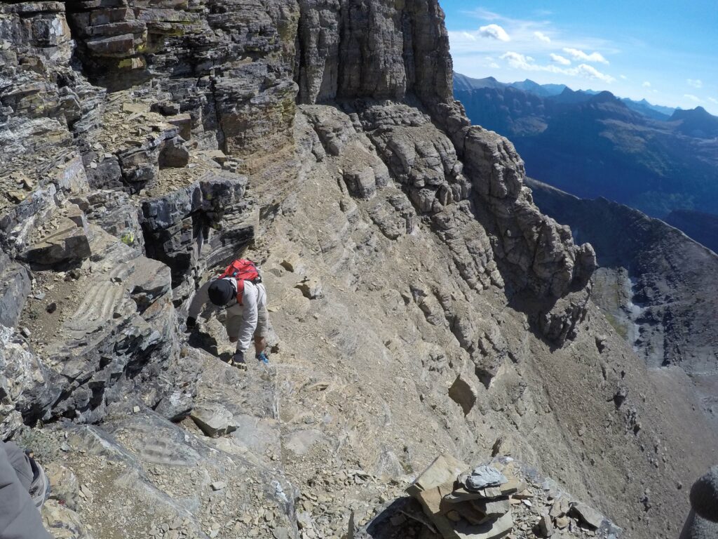 man climbing a mountain in glacier national park